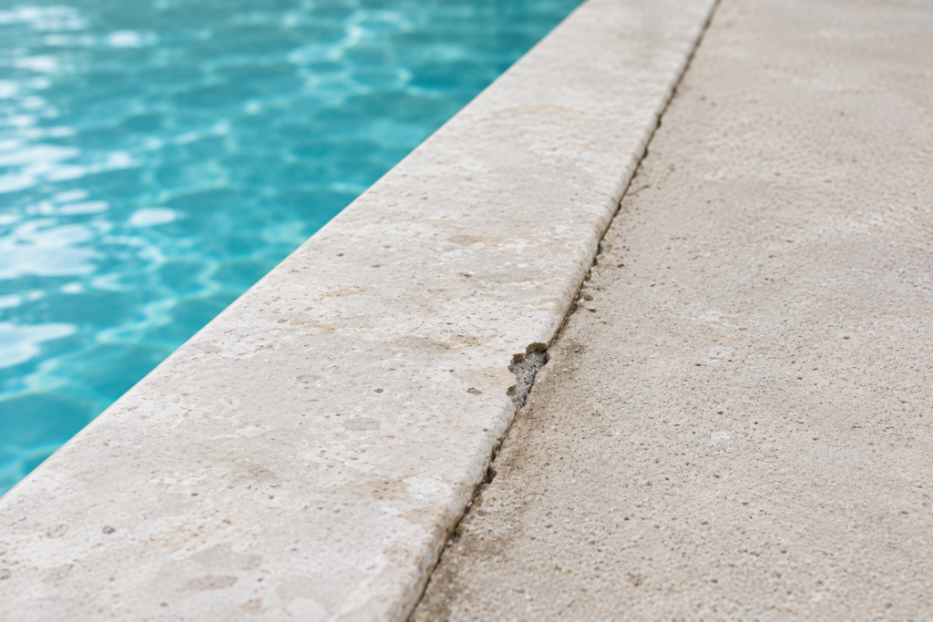 Crack along the junction between pool coping and terrace deck