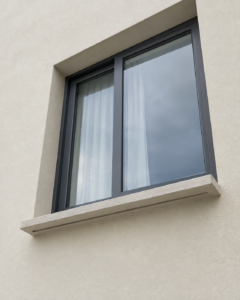 Recessed window with a projecting sloped sill and a drip groove cut into its underside